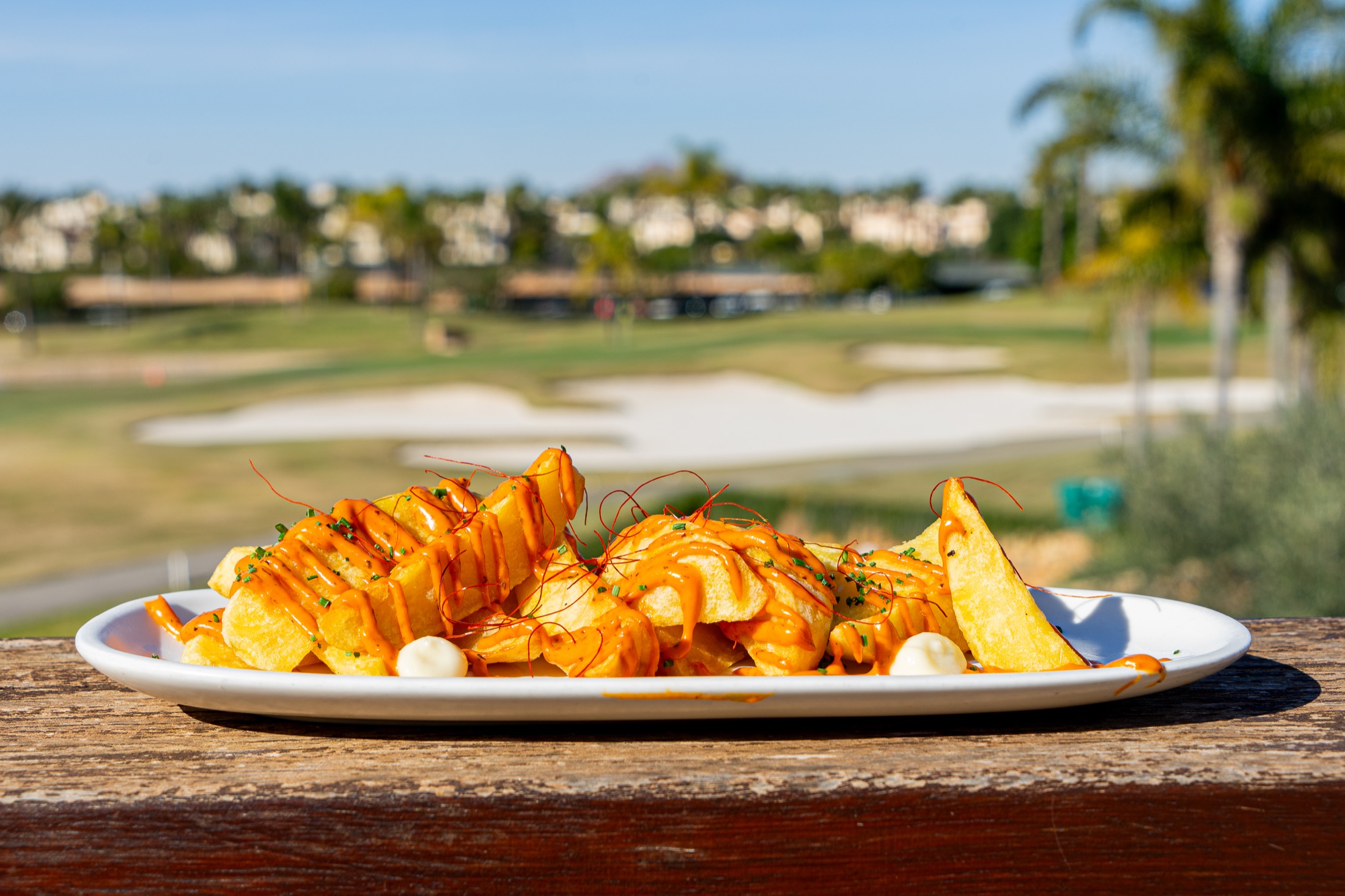 Plato servido en terraza con vistas al campo de golf