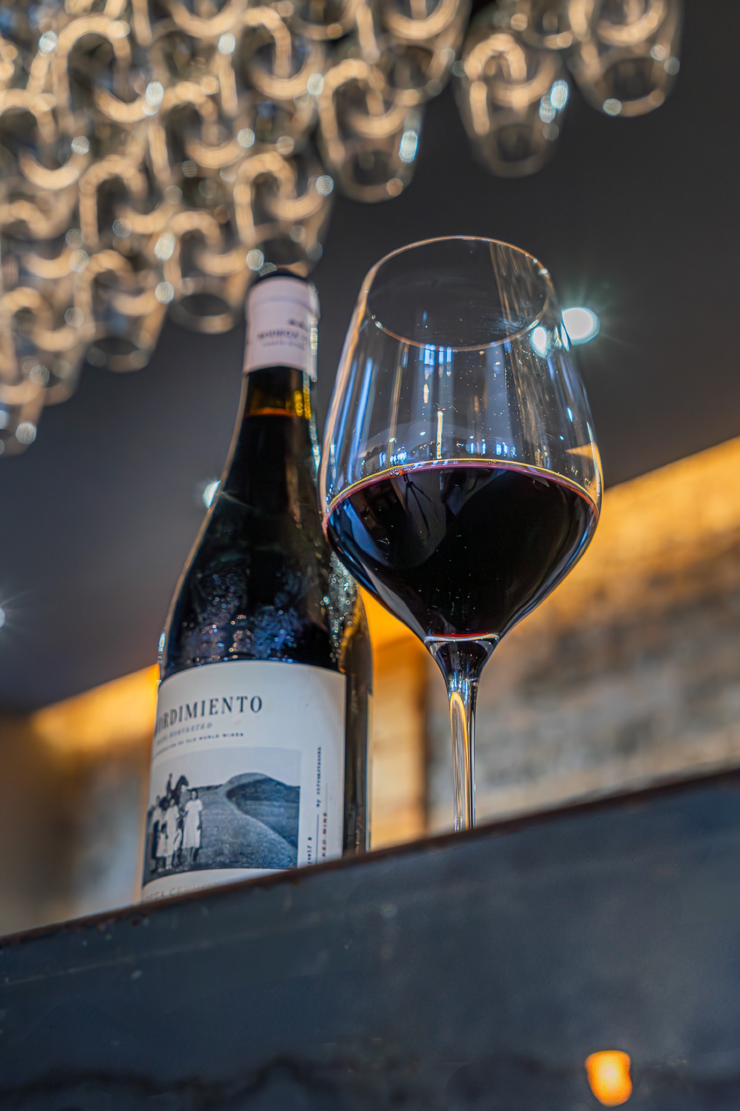 Botella y copa de vino en ambiente elegante
